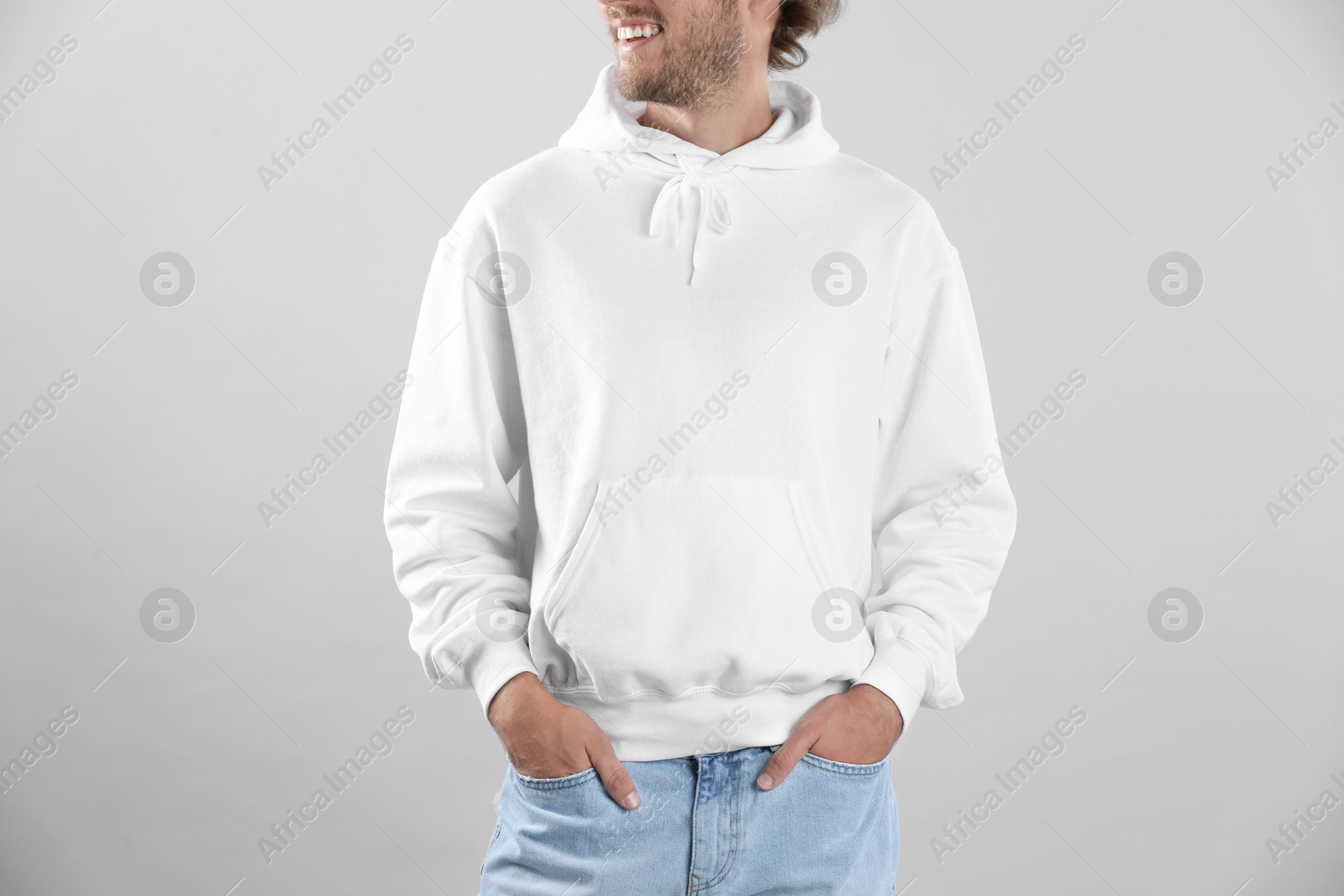 Photo of Man in hoodie sweater on light background. Space for design