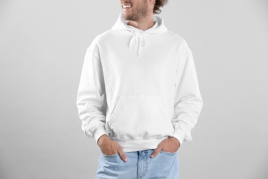 Photo of Man in hoodie sweater on light background. Space for design