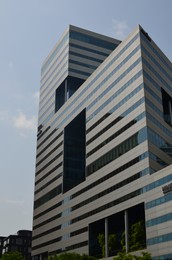 Exterior of beautiful modern skyscraper against blue sky