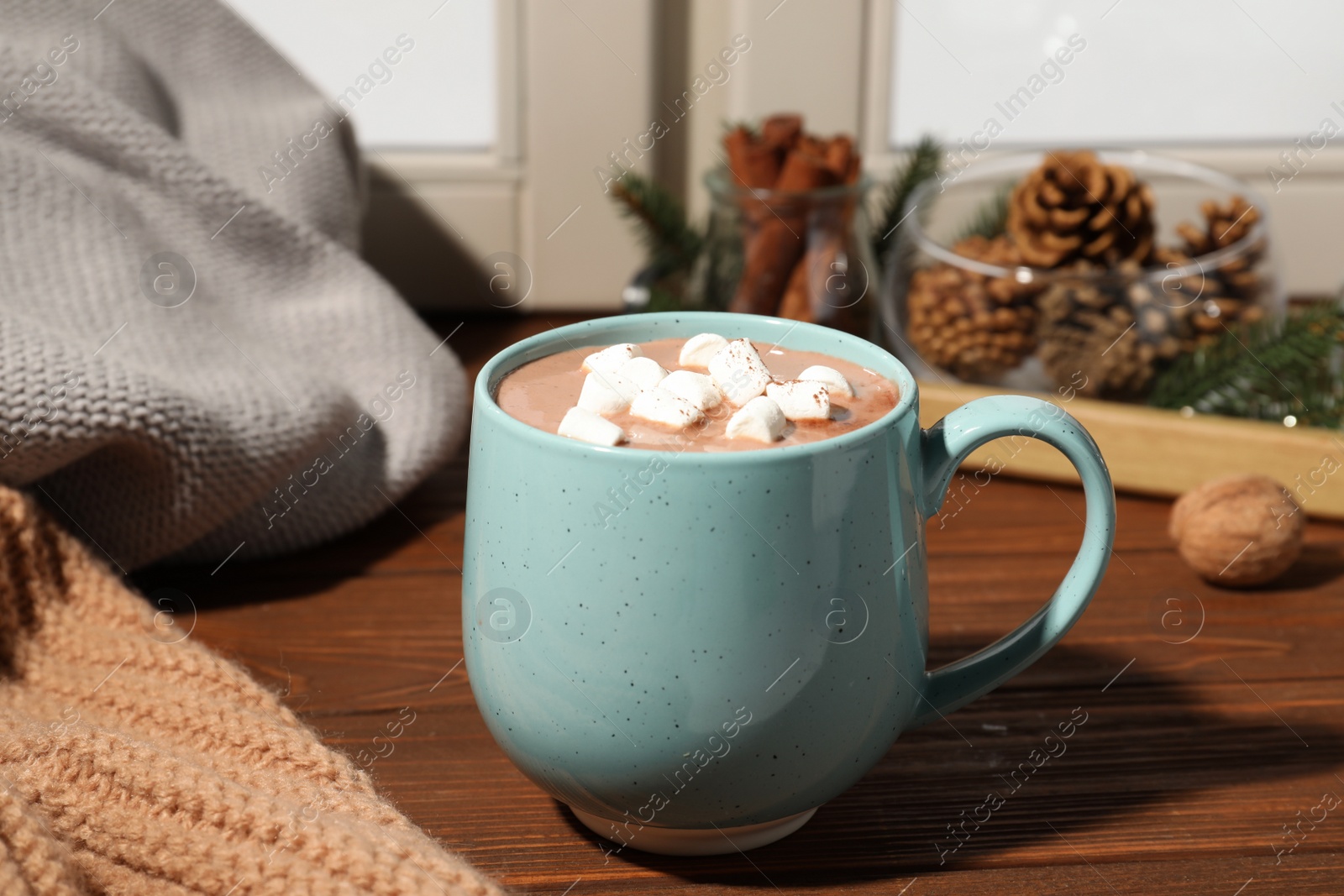 Photo of Cup of cocoa with marshmallows on windowsill indoors. Winter drink