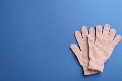 Photo of Pair of stylish woolen gloves on blue background, flat lay. Space for text