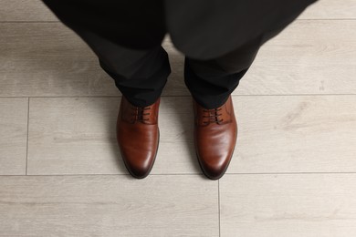 Businessman in elegant leather shoes on floor, above view