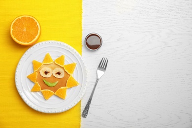 Flat lay composition with pancake in form of sun on table. Creative breakfast ideas for kids