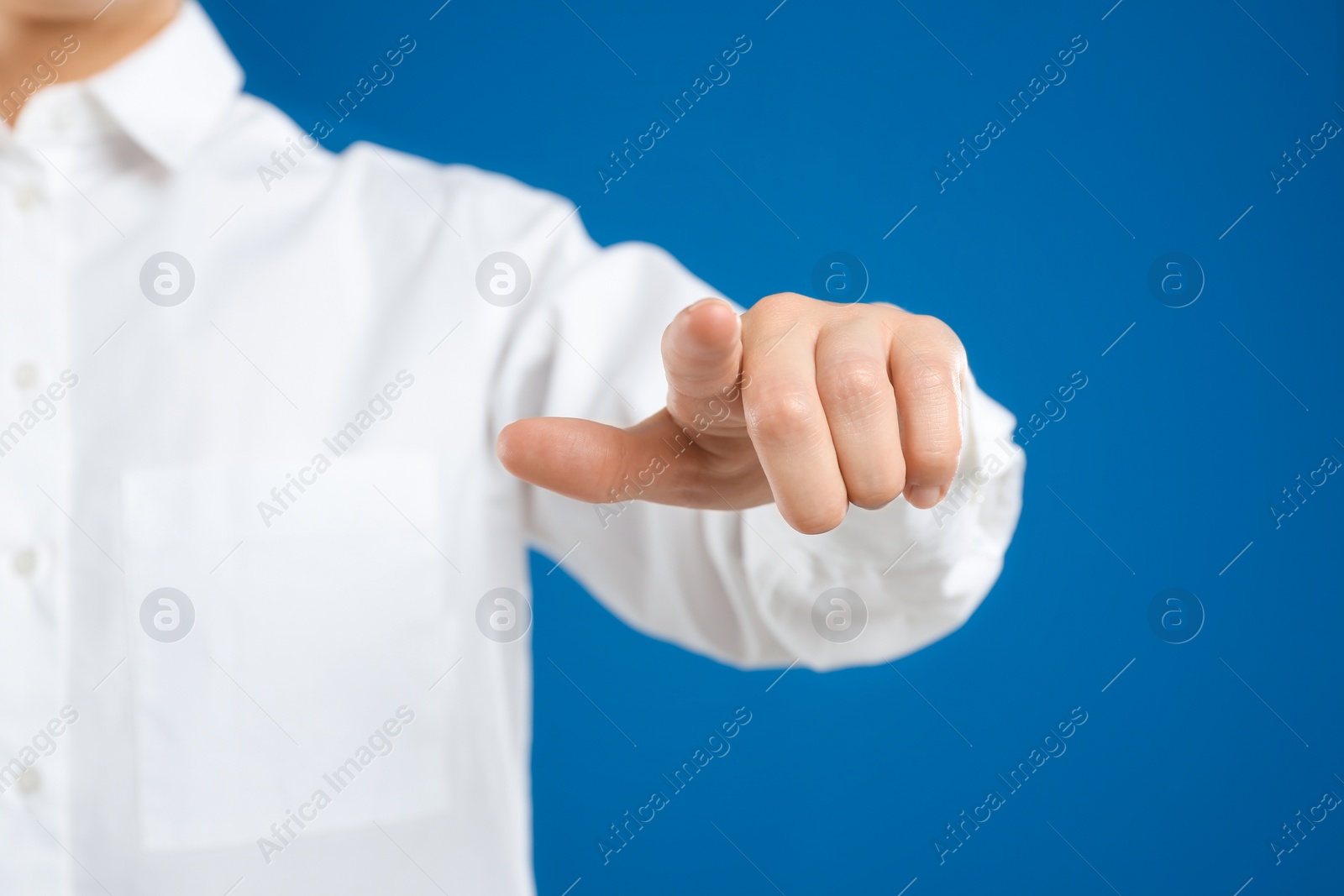 Photo of Woman touching something against blue background, focus on hand