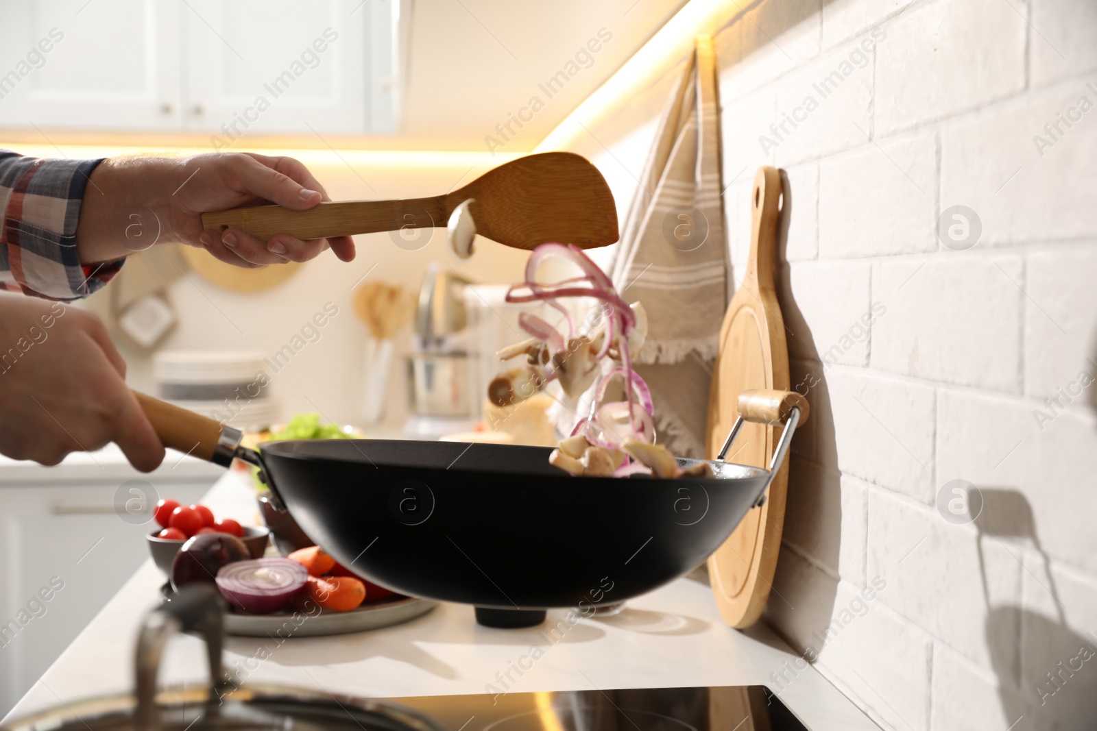 Photo of Man cooking cut vegetables in frying pan, closeup