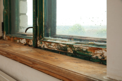 Photo of Old window with wooden sill in room, closeup