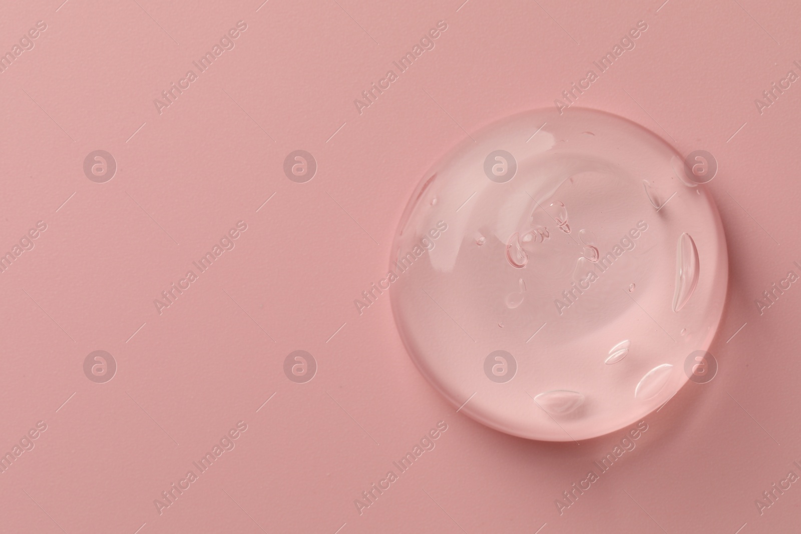 Photo of Sample of clear cosmetic gel on pink background, top view. Space for text
