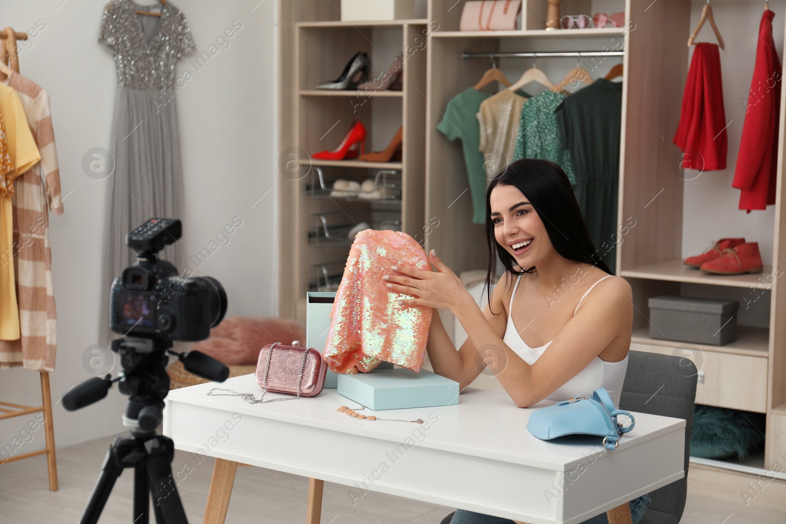 Photo of Fashion blogger recording new video at table indoors