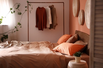 Bed with orange and brown linens in stylish room