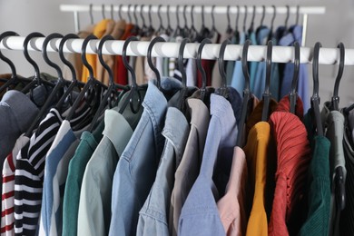 Photo of Rack with stylish clothes on blurred background, closeup. Fast fashion