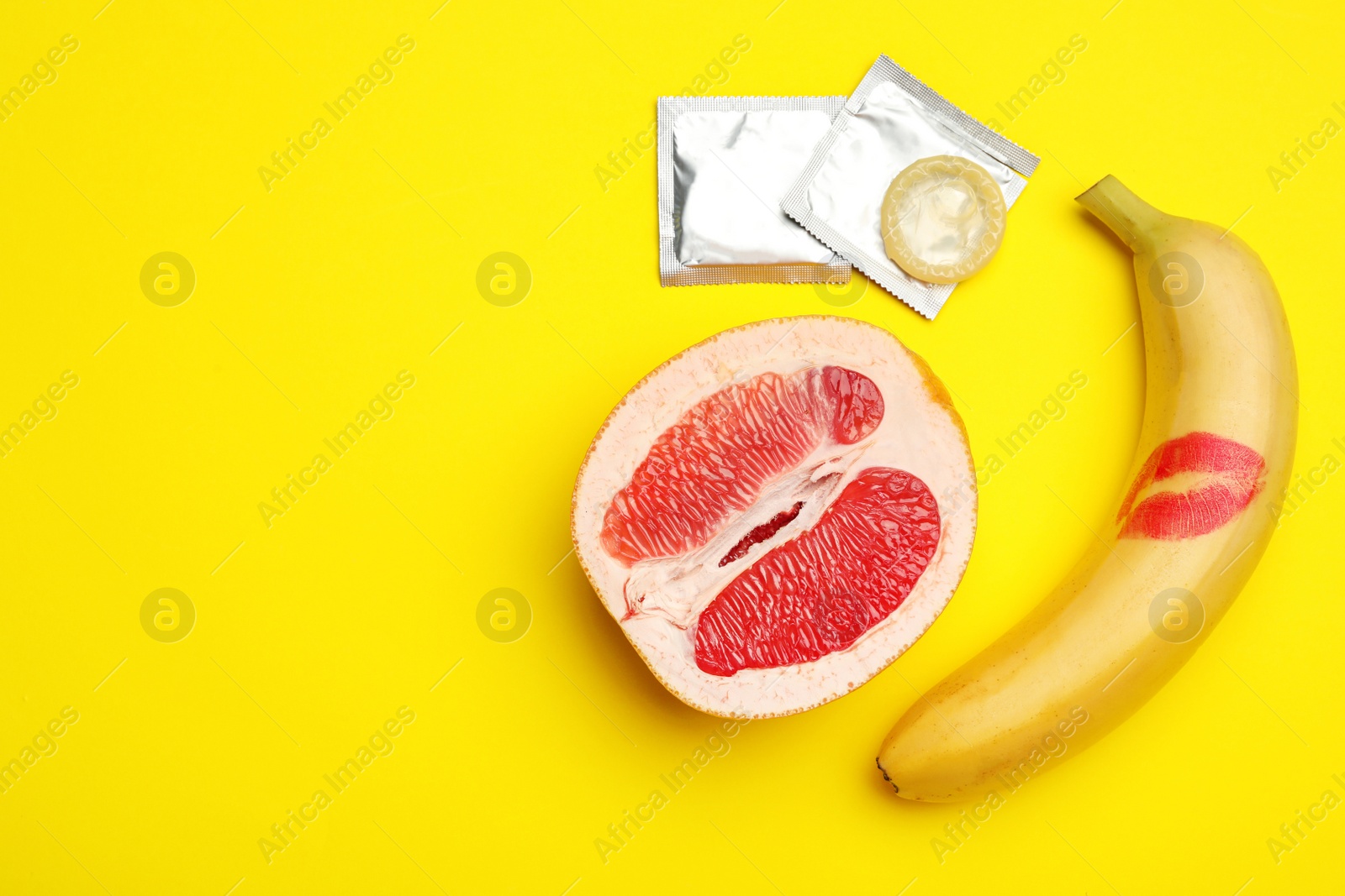 Photo of Flat lay composition with condoms and space for text on yellow background. Safe sex