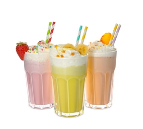 Photo of Glasses of tasty milk shakes on white background