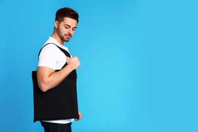 Photo of Portrait of young man with eco bag on blue background. Space for text