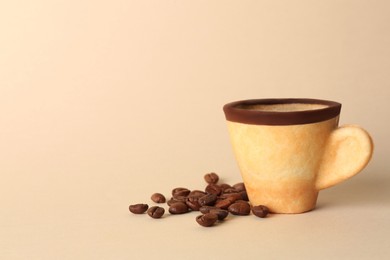 Photo of Delicious edible biscuit cup with espresso and coffee beans on beige background. Space for text