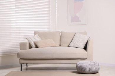 Photo of Stylish soft sofa with cushions in living room. Interior design
