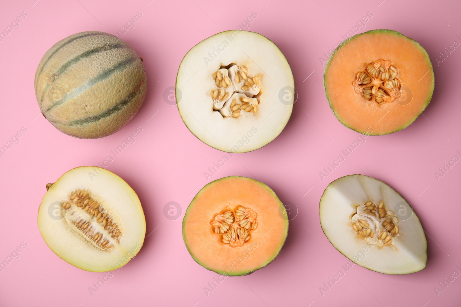 Photo of Tasty colorful ripe melons on pink background, flat lay