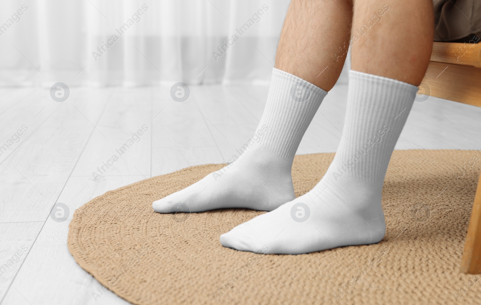 Photo of Man in stylish white socks in armchair indoors, closeup. Space for text