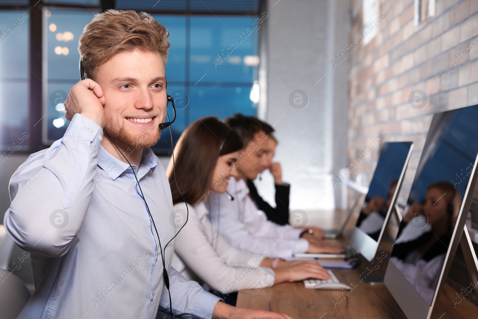 Photo of Technical support operator with colleagues in modern office