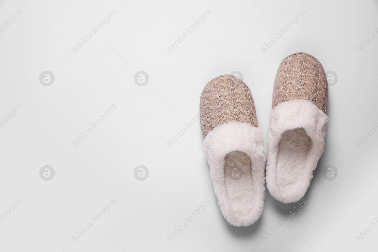 Photo of Pair of beautiful soft slippers on white background, top view. Space for text