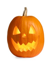 Photo of Carved pumpkin for Halloween lit from within by candle isolated on white