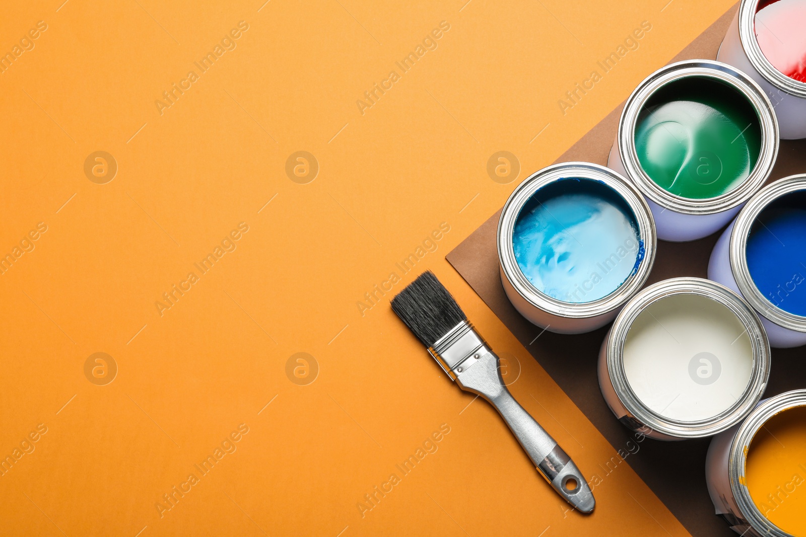 Photo of Flat lay composition with paint cans and space for text on color background