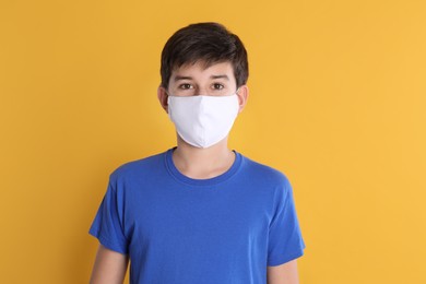 Boy wearing protective mask on yellow background. Child safety