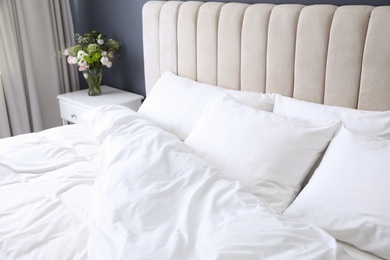 Comfortable bed with soft pillows indoors, closeup