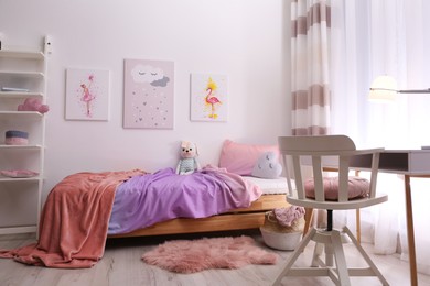 Comfortable bed with pink linens in children's room