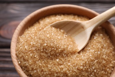 Photo of Bowl and spoon with brown sugar on table, closeup