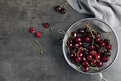 Photo of Sieve with sweet red cherries on table, top view