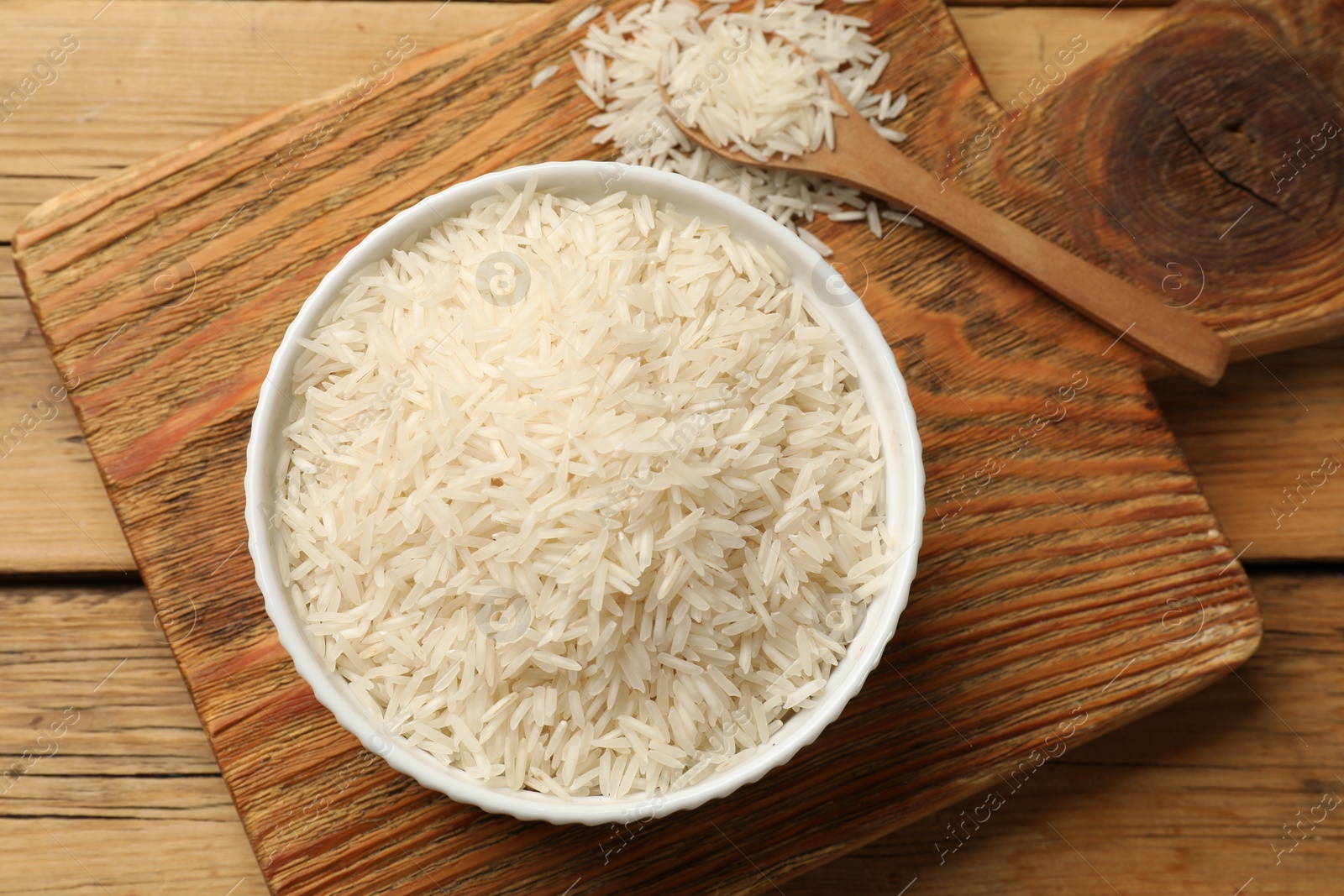 Photo of Raw basmati rice on wooden table. flat lay