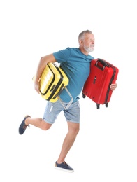 Senior man with suitcases running on white background. Vacation travel