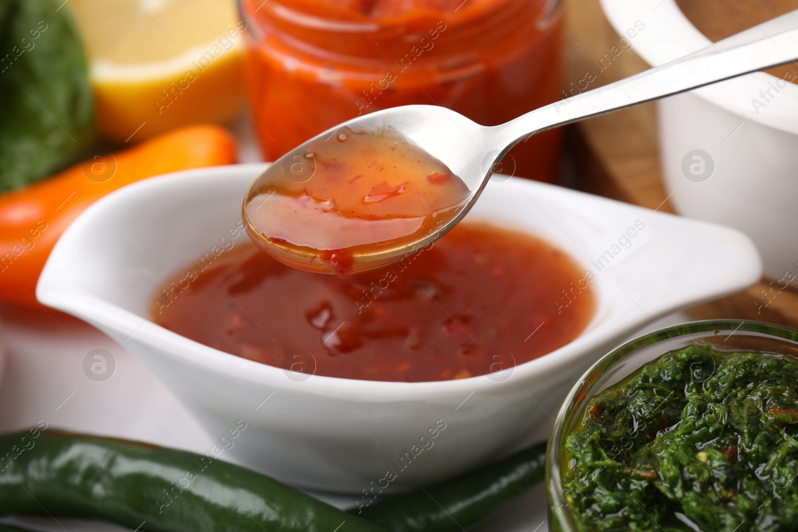 Photo of Taking homemade marinade from bowl at table, closeup