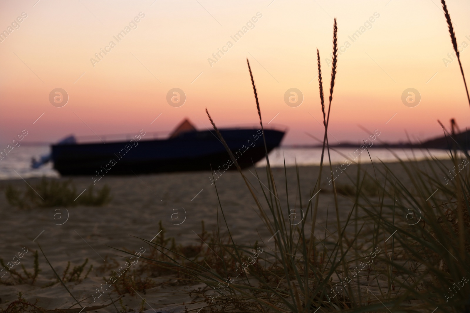 Photo of Beautiful view of beach with boat at sunset