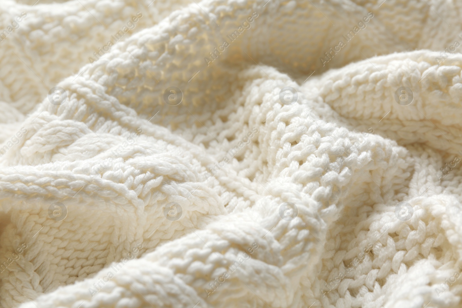 Photo of White knitted fabric with beautiful pattern as background, closeup