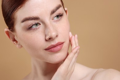 Portrait of beautiful woman on beige background, closeup