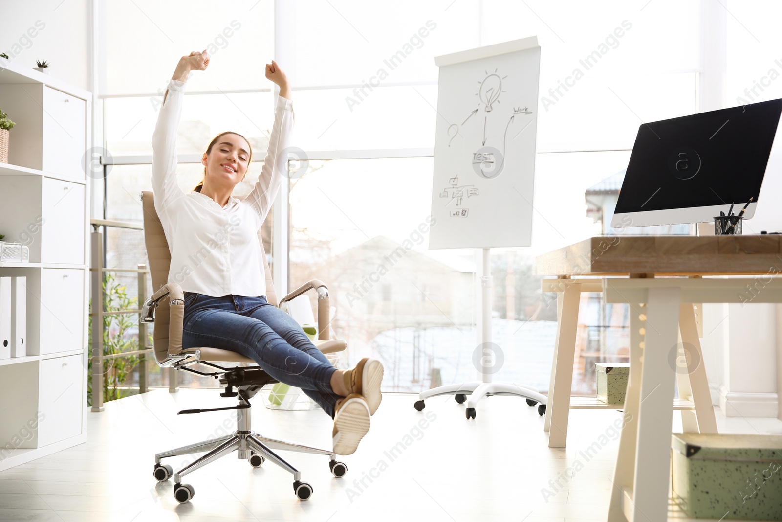 Photo of Young woman relaxing in office chair at workplace