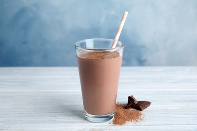 Glass with tasty chocolate milk on wooden table. Dairy drink