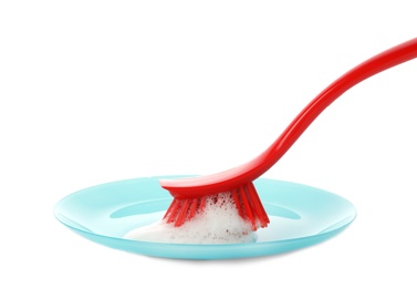 Photo of Cleaning dish with brush on white background