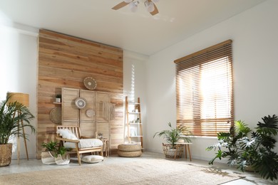 Stylish living room interior with comfortable wooden armchair and beautiful houseplants