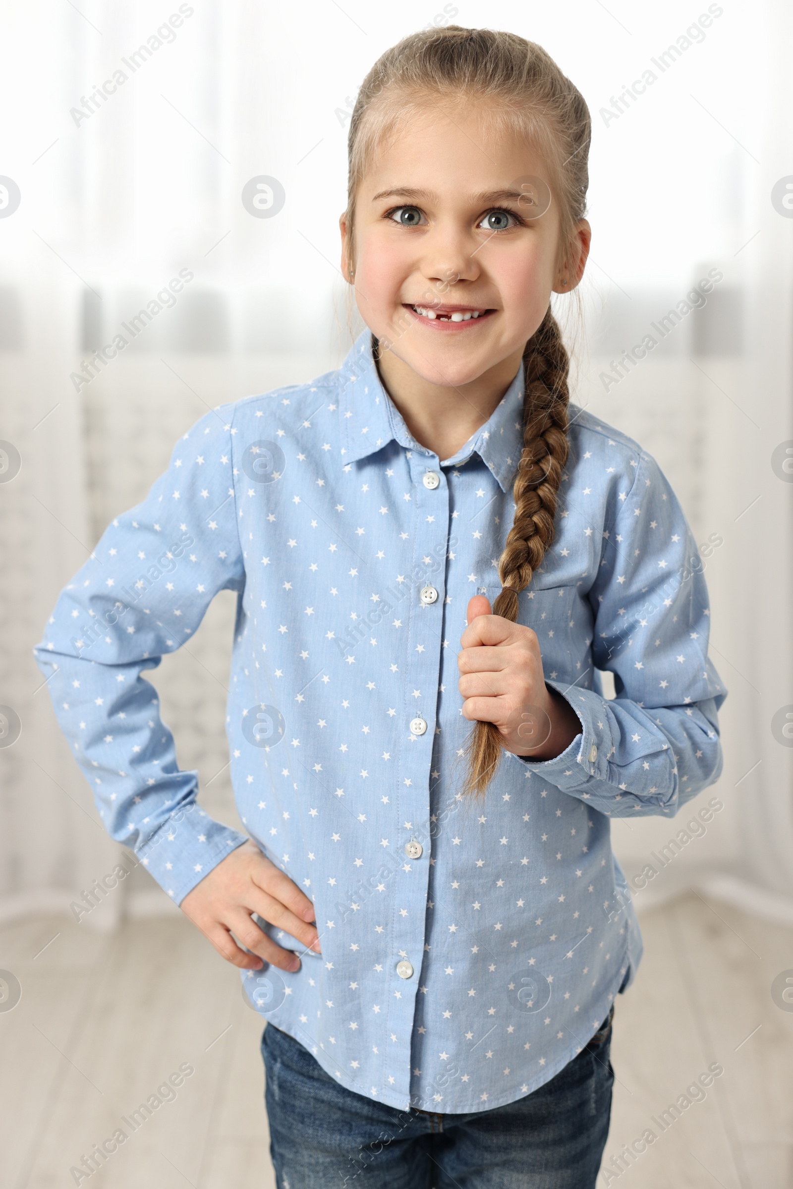 Photo of Cute little girl with braided hair indoors