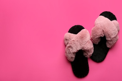 Photo of Pair of soft slippers on pink background, flat lay. Space for text