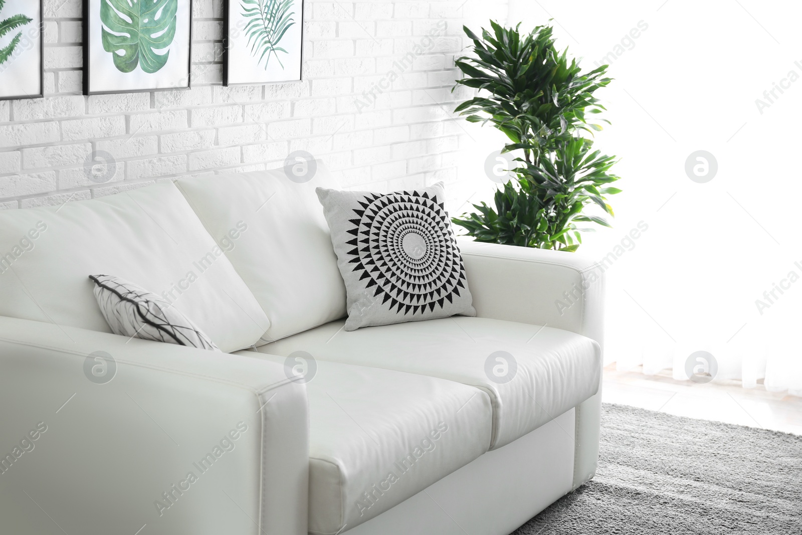 Photo of Comfortable white sofa in modern room. Interior design