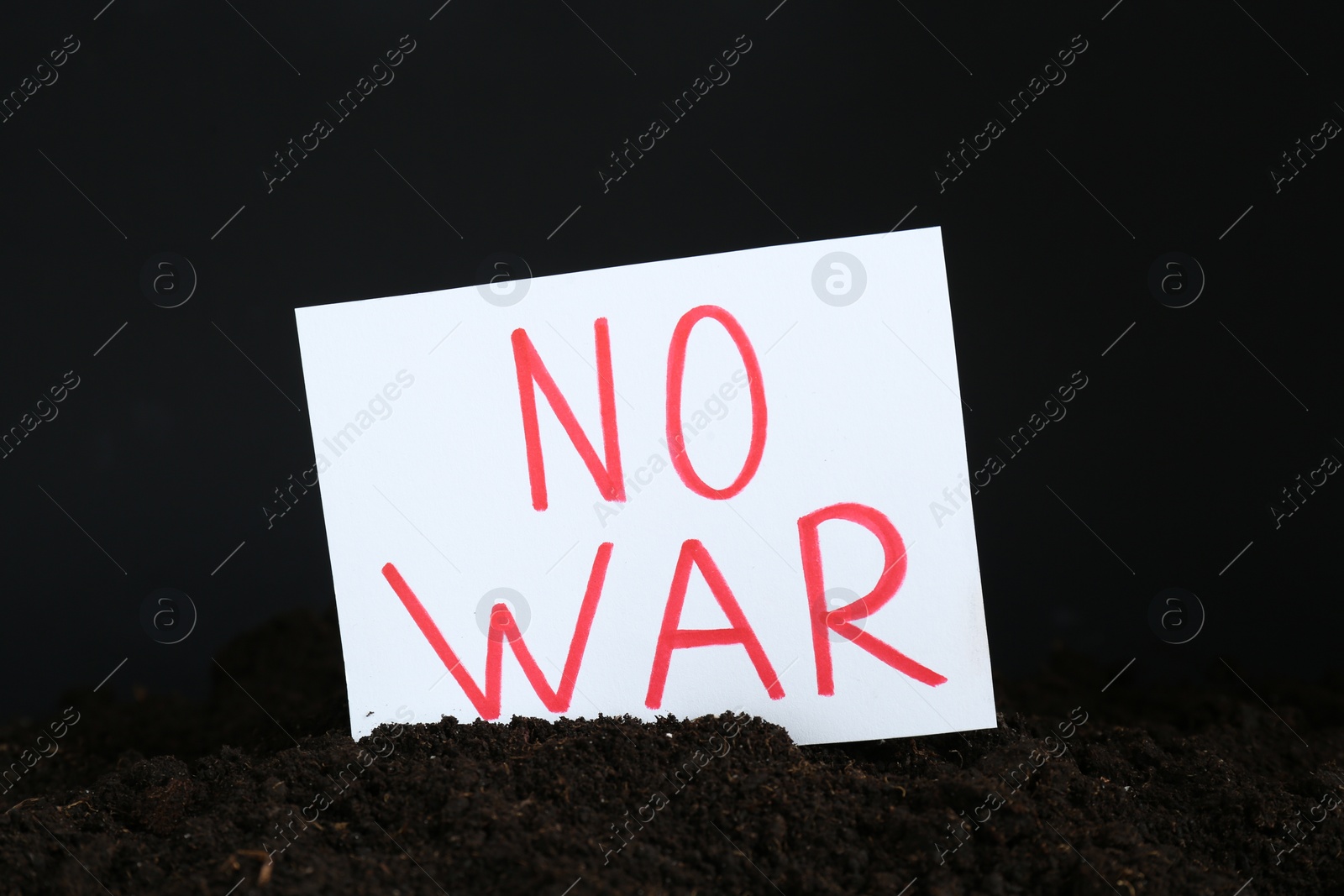 Photo of Card with words No War in soil