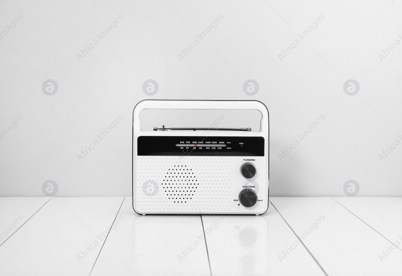 Photo of Retro radio receiver on white wooden table