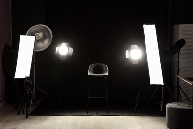 Photo of Interior of modern photo studio with chair and professional lighting equipment