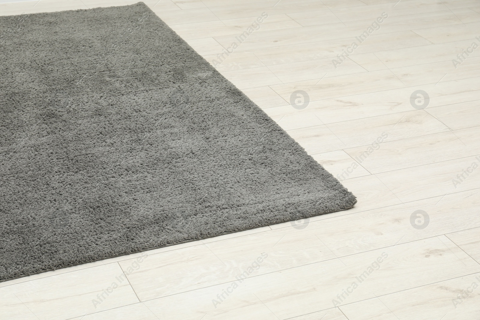 Photo of Soft grey carpet on white laminated floor indoors