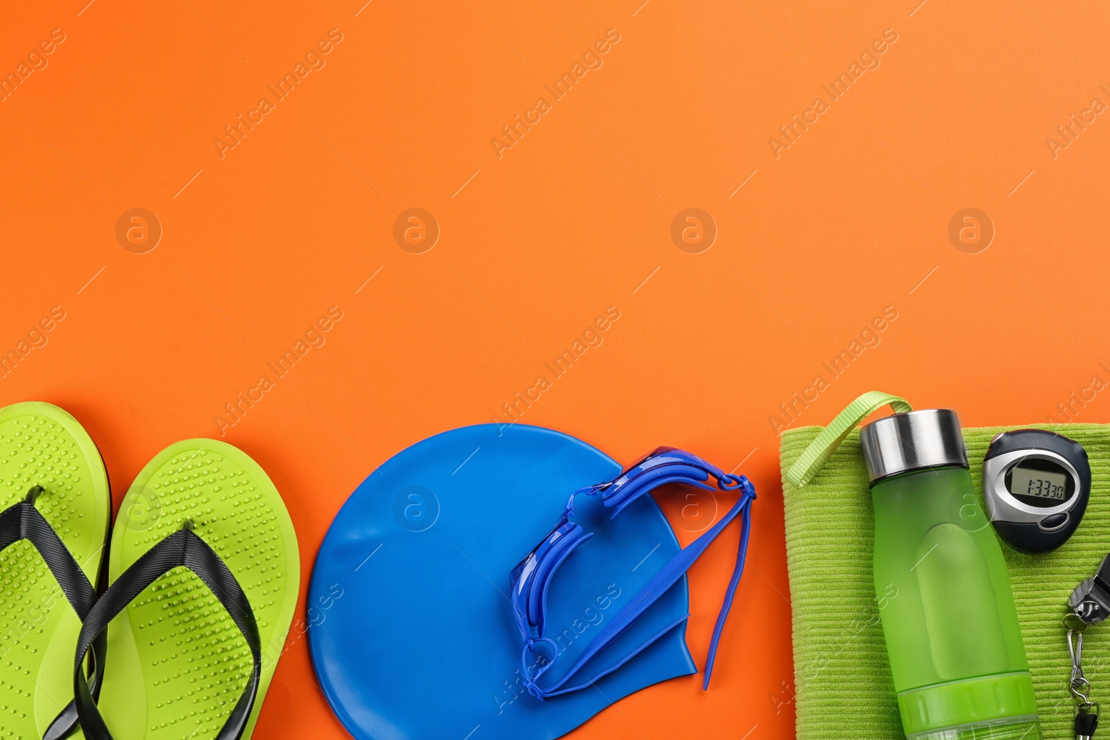 Photo of Flat lay composition with swimming accessories on orange background. Space for text