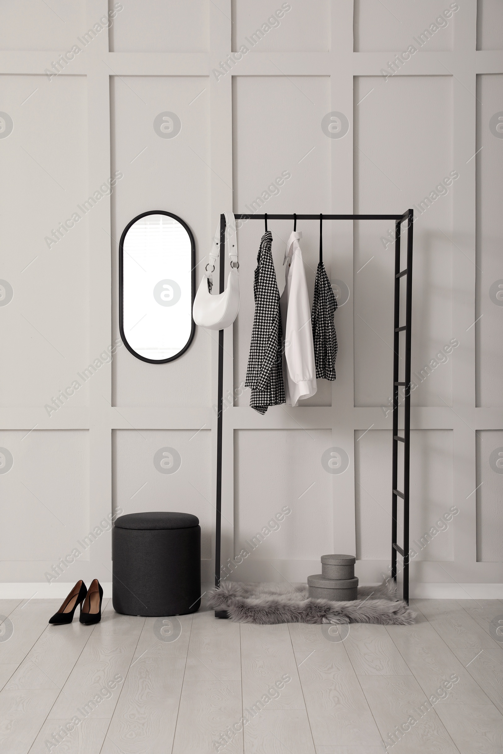 Photo of Simple hallway interior with clothing rack and mirror