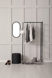 Photo of Simple hallway interior with clothing rack and mirror